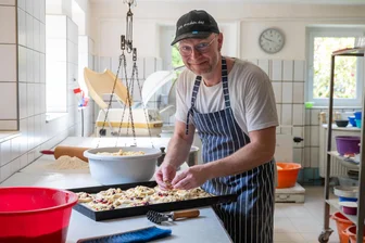 Bäckerei-Sterben? Ohne uns! Bäcker-Familie im Erzgebirge seit 18 Generationen am Backofen - Michael Gräbner streut noch ein paar Streusel auf die Backwaren. Seinem Sohn stellte er frei, auch etwas völlig anderes zu machen.