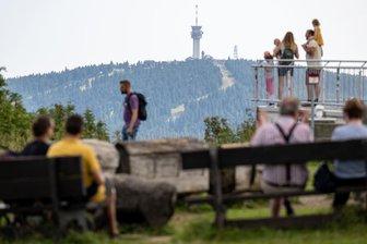„Das Problem liegt ganz woanders“ – Touristiker reagieren gelassen auf Debatte um Rechtsruck in Aue - Besucher des Fichtelbergs genießen den Ausblick. Der 1215 Meter hohe Berg ist im Sommer wie auch im Winter ein Anziehungspunkt für zahlreiche Urlauber in der Region.