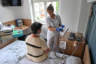 Eine Nacht im Schlaflabor: Was ist überhaupt Schlaf, Herr Professor? - Schwester Andrea Lauterbach verkabelt Patientin Marion Klose vor dem Zu-Bett-gehen mit 18 Kabeln und zwei Gurten.