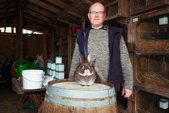 „Erst Hasen füttern, dann das Bier“: Wer will heute noch Kaninchen züchten? - Silvio Pause und sein Kaninchen posieren fürs Foto.