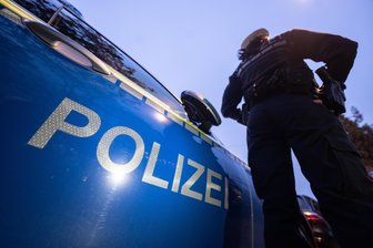 Supermoto-Maschine in St. Egidien gestohlen - Eine Polizistin steht neben einem Polizeifahrzeug.